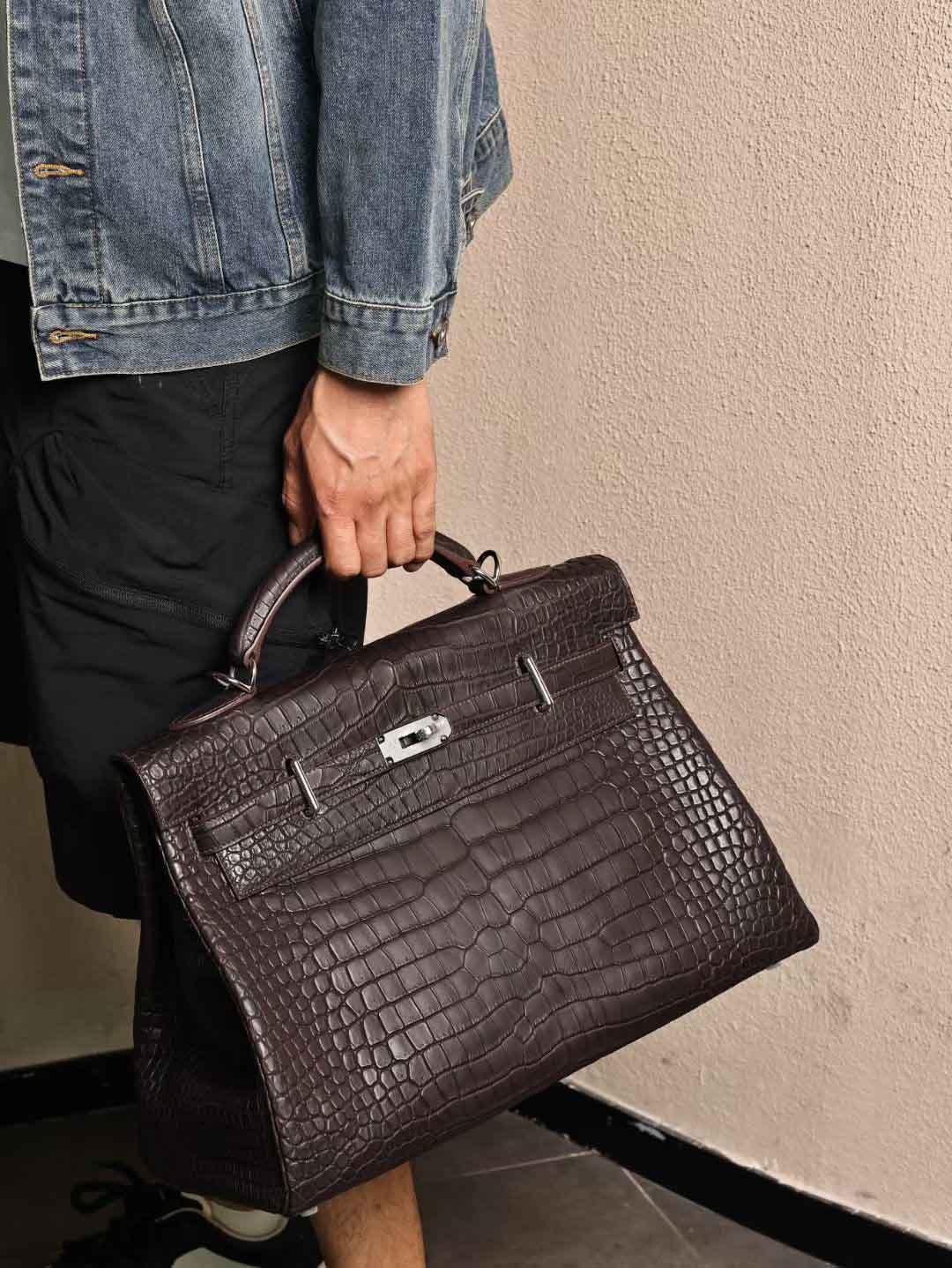 Kelly Maxi42，乌木色HCP哑光湾鳄，银扣实拍现货。 kelly maxi42 为男包天花板，不仅是因为价格，实用性方面完全没有任何问题。 采用HCP湾鳄材质，属于高定版本，需客订出货 ‌。 展现了湾鳄一贯的精致与高贵，又不失商务人士所需的实用性和功能性。湾鳄设计简洁大方，线条